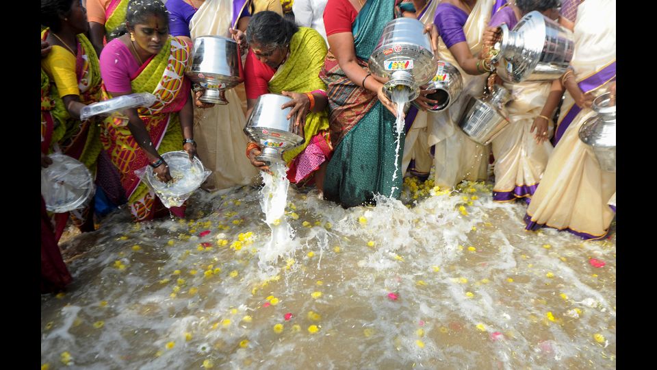 Donne indiane versano il latte nel mare come offerta in commemorazione delle vittime dello tsunami del 2004 a Marina Beach, Chennai in India (foto Afp)