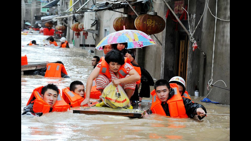 Alcuni cittadini di Nindge cercano di mettersi in salvo dopo il passaggio del tifone Megi che ha colpito molte zone della Cina orientale e provocato morte e distruzione a Taiwan (foto Afp)&nbsp;