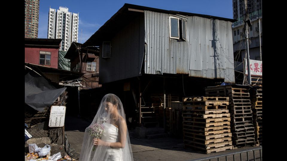 Giovane sposa in posa per le foto di nozze ai mercati generali di frutta a Hong Kong (foto Afp)&nbsp;