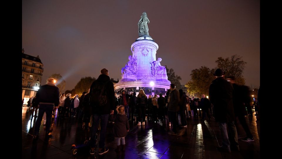 Una cerimonia improvvisata ai piedi della statua Marianne a Place de la Republique a Parigi in commemorazione del primo anniversario degli attacchi terroristici a Parigi. Il 13 novembre del 2015 un commando dell'Isis fece strage di 130 persone in diversi luoghi della capitale francese (foto Afp)