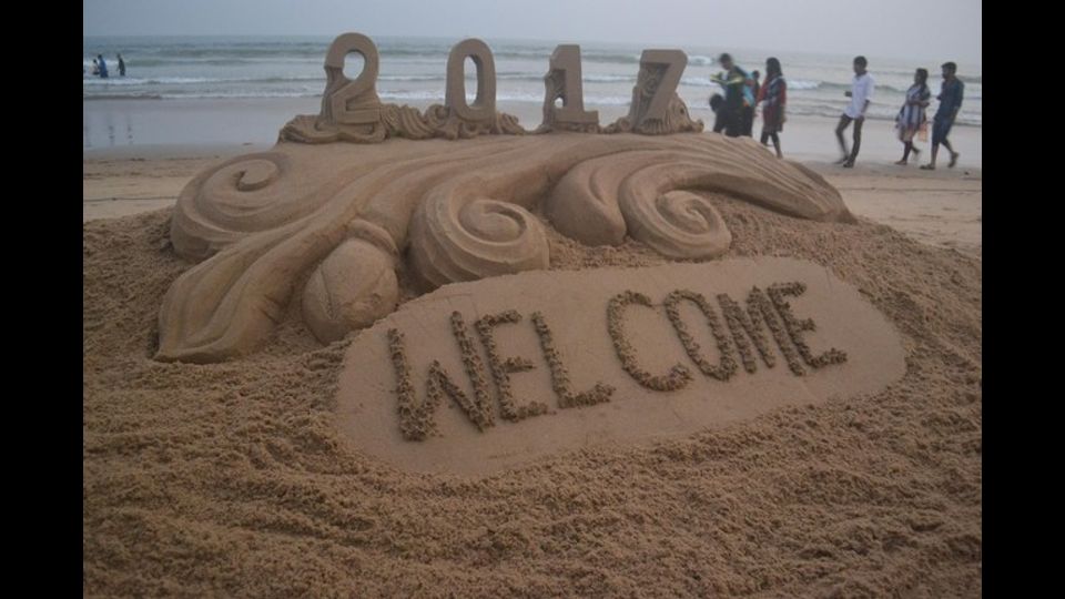&nbsp;Una scultura di sabbia creata dall'artista Sudarshan Pattnaik a Puri in India, che simboleggia il passaggio dal vecchio al nuovo anno (foto Afp)