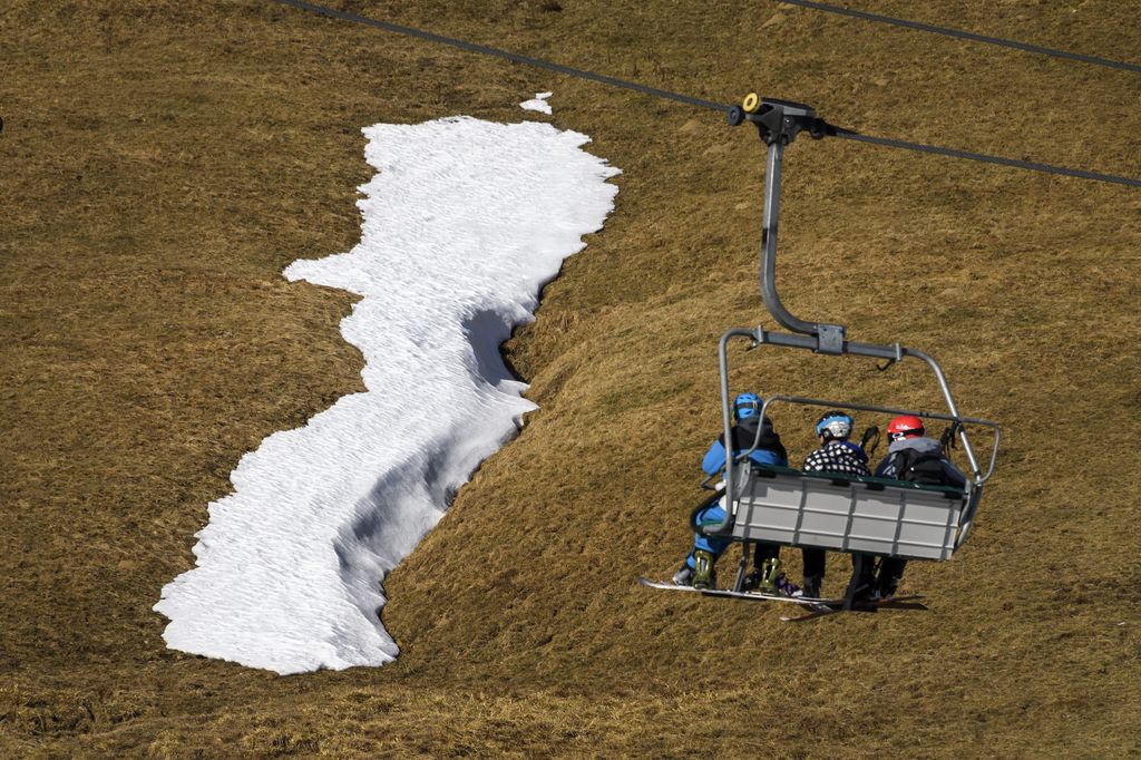 Un gruppo di sciatori siedono&nbsp;su un impianto di risalita in un paesaggio senza neve nella localit&agrave; di Les Crosets sulle Alpi svizzere. La Svizzera ha appena vissuto la stagione pi&ugrave; secca degli ultimi 150 anni. Altre localit&agrave; nella parte occidentale del paese non hanno visto un solo fiocco di neve o goccia di pioggia (foto Afp)