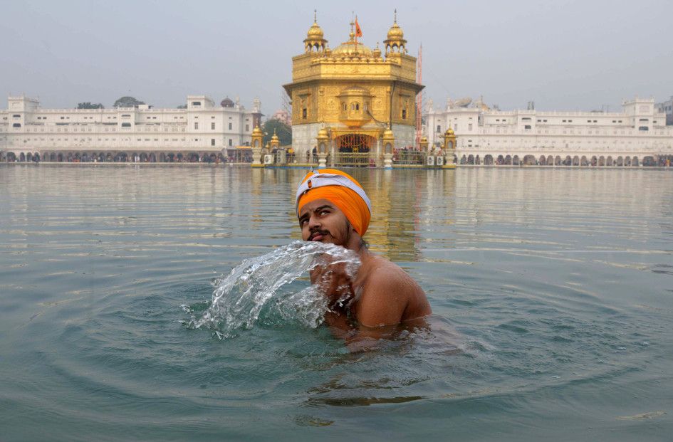 Un devoto indiano Sikh fa il bagno nel fiume sacro Sarovar, presso il Santuario Sikh Golden Temple di Amritsar , nel corso di un 'Jalau', lo spettacolo di elementi simbolici di Sikhismo (foto Afp)&nbsp;