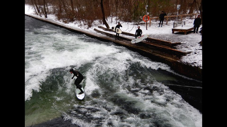 Gli amanti del surf non si lasciano spaventare dalla neve. E a Monaco di Baviera, cavalcano le onde gelide del canale dell'Eisbach, il piccolo fiume artificiale che attraversa l'Englischer Garten - il 'Giardino Inglese'- pi&ugrave; precisamente Prinzregentenstra&szlig;e, a pochi passi dal centro della citt&agrave;. Nonostante il mare disti oltre 500 chilometri e ci sia il divieto di balneazione, negli ultimi 45 anni l'Eisbach &egrave; diventato una tappa imperdibile per chi si cimenta nel&nbsp;'river surfing'. A detta dei pi&ugrave; esperti, fare surf sull&rsquo;onda anomala dell&rsquo;Eisbach &egrave; difficile per via della corrente e del poco spazio a disposizione tra le due sponde del fiume. (foto Afp)