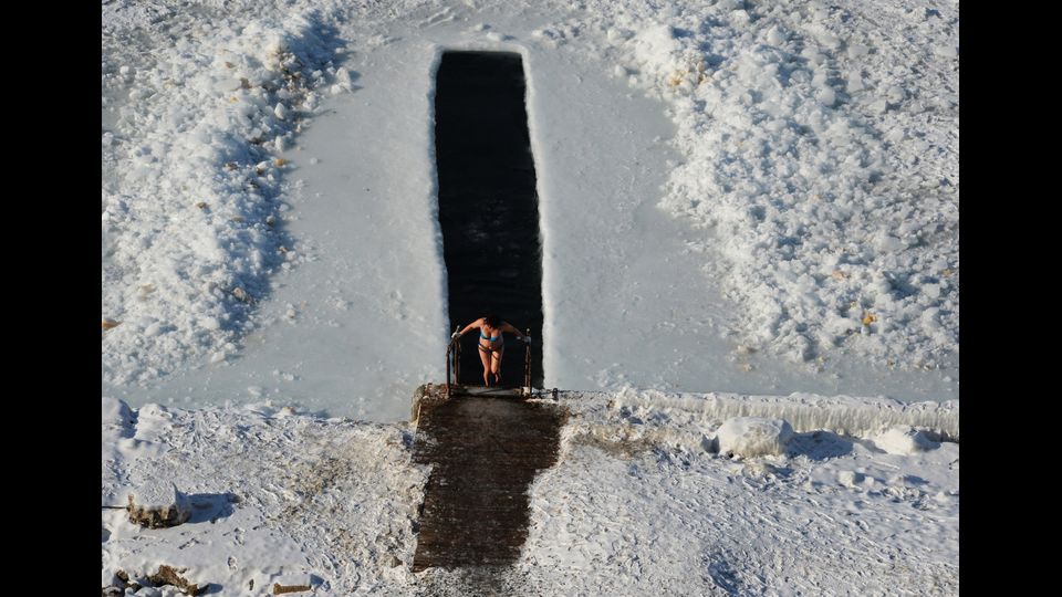 &nbsp;Vladivostok, il bagno di una donna russa tra i ghiacci di Amur Bay, nell'estremo oriente della Russia (foto Afp)