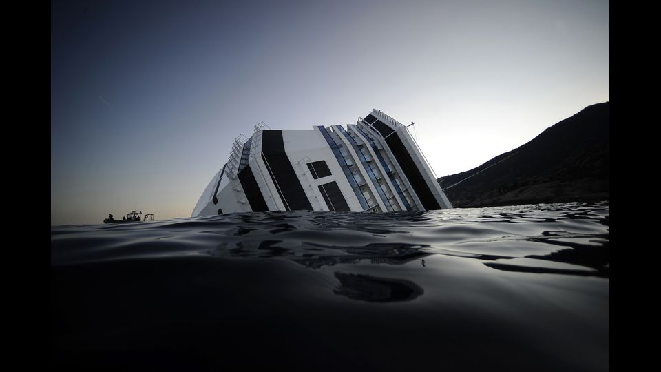 13 gennaio 2012, ore 21.45. La Costa Concordia, gioiello della flotta Costa Crociere, urta gli scogli dopo uno spericolato 'inchino' all'isola del Giglio. La fiancata imbarca acqua. La nave cede e si inclina, inabissandosi lentamente ma inesorabilmente (Afp)
