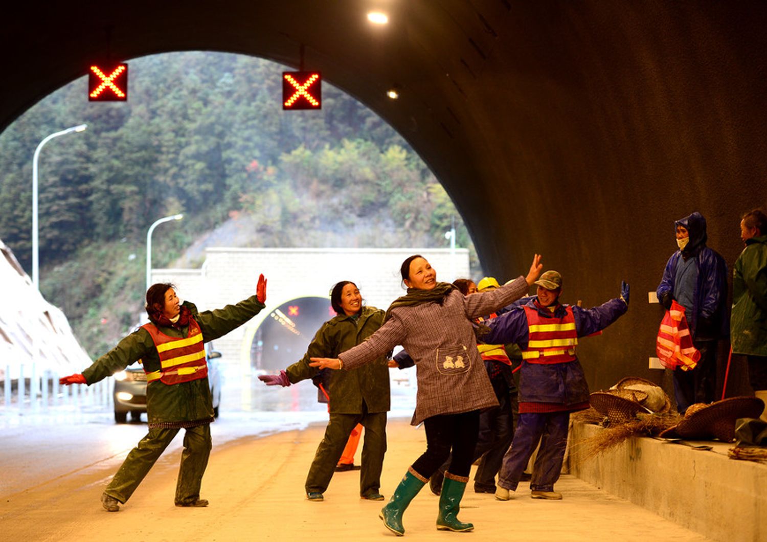 Cina, operai addetti alla costruzione del tunnel di Sanjiang-Liuzhou Expressway a Liuzhou danzano per scaldarsi durante la pausa pranzo. Il tunnel dovrebbe essere aperto per la Festa della Primavera che cade il 28 gennaio (foto Afp)