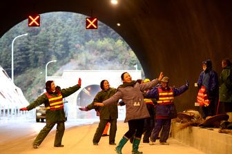 Cina, operai addetti alla costruzione del tunnel di Sanjiang-Liuzhou Expressway a Liuzhou danzano per scaldarsi durante la pausa pranzo. Il tunnel dovrebbe essere aperto per la Festa della Primavera che cade il 28 gennaio (foto Afp)