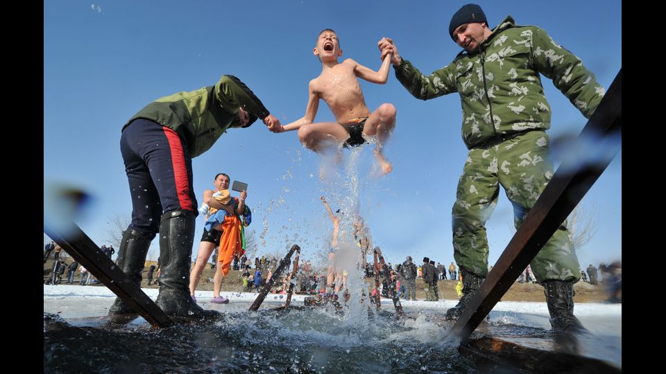 Cosacchi aiutano un ragazzo a fare un bagno nelle acque ghiacciate di un lago durante la celebrazione della festa dell'Epifania vicino al villaggio di Leninskoe a circa 15 chilometri di Bishkek (afp)&nbsp;