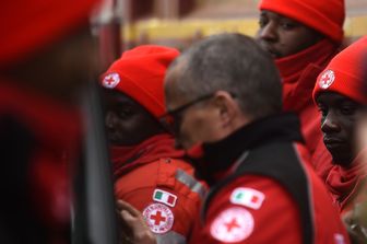 Un gruppo di migranti lavora insieme alla Croce Rossa al centro di coordinamento di operazioni a Penna (Afp) &nbsp;