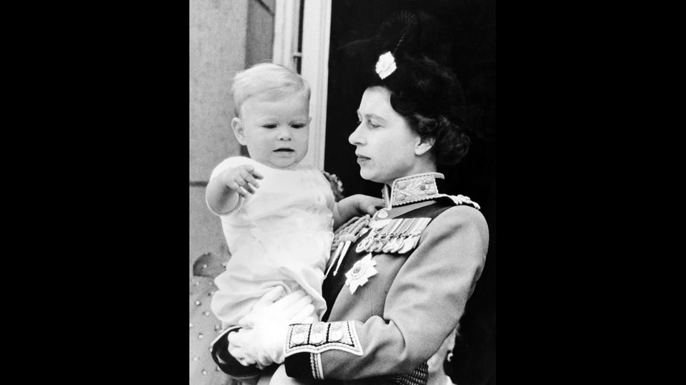 &nbsp;La regina Elisabetta II con il piccolo principe Andrea si affacciano al balcone di Buckingham Palace, dopo la parata per il compleanno della regina, 12 giugno 1961 (foto Afp)