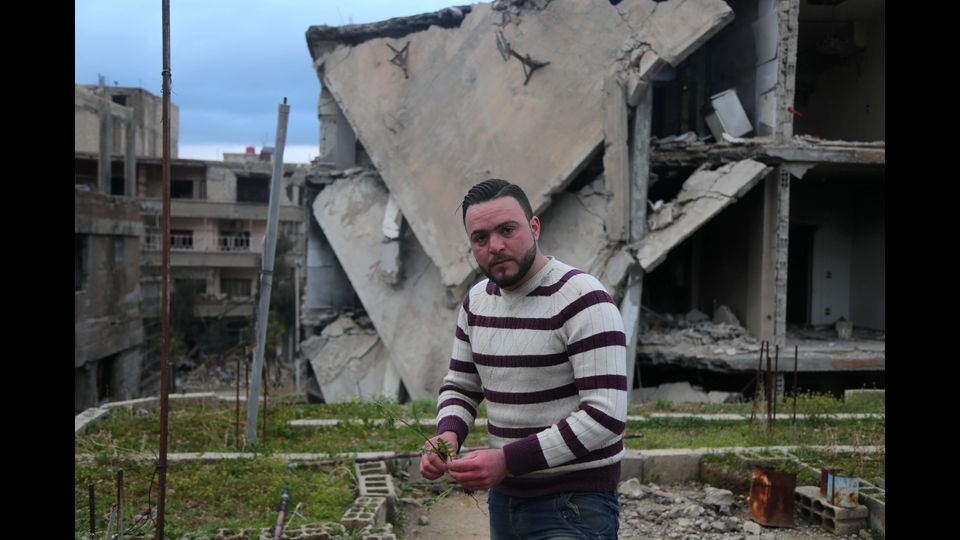 Mohamed Ataya, siriano 31enne che prima della guerra era un giocatore di calcio noto come &quot;Abu Maher&quot;, annaffia le sue piante sul tetto della sua casa danneggiata ad Arbin, nella regione Ghouta orientale, alla periferia della capitale Damasco il 3 marzo 2017. Ataya coltiva i semi per la vendita. (Foto Afp)&nbsp;