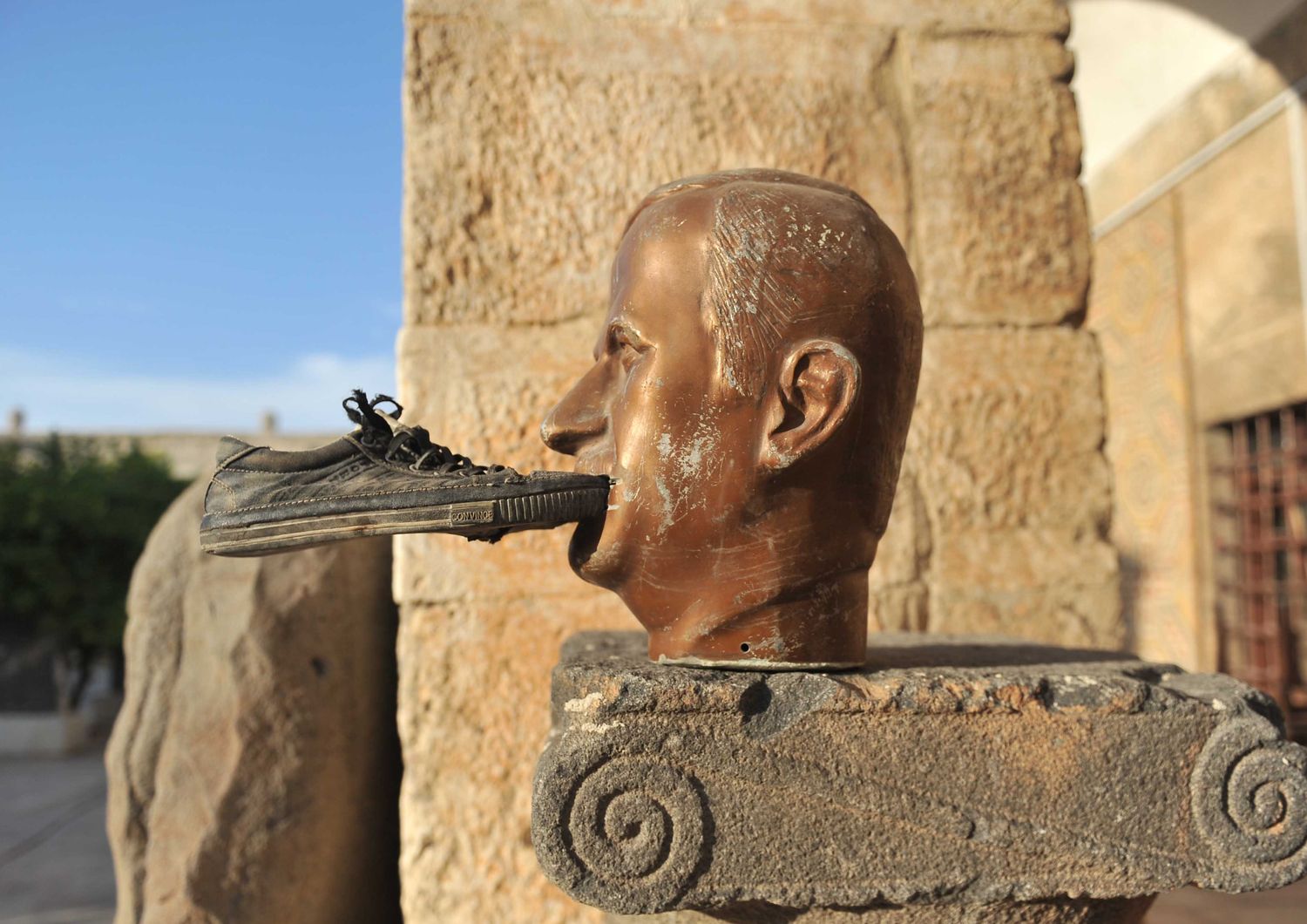 &nbsp;Una scarpa ficcata in bocca a una statua di Hafez al Assad, padre del presidente siriano Bachar