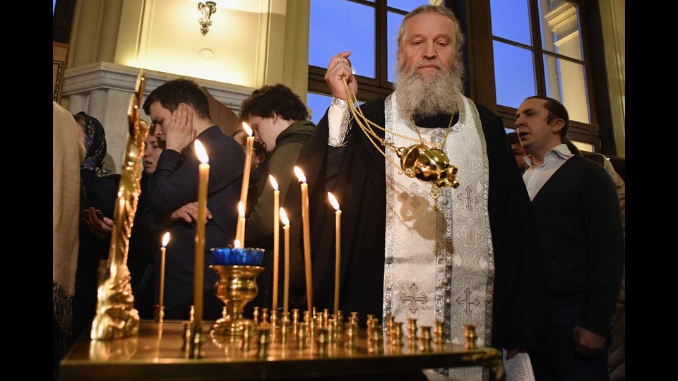 Un prete ortodosso celebra una preghiera in memoria delle vittime dell'esplosione nella metropolitana di San Pietroburgo in una cappella alla stazione ferroviaria di Leningradsky a Mosca (foto Afp)&nbsp;