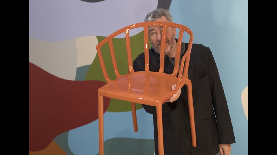 Il designer francese Philippe Starck con il suo modello di sedia Kartell (Afp)&nbsp;