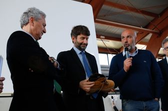 &nbsp;Amatrice, il sindaco Pirozzi consegna uno scarpone a Dario Franceschini (Agf)