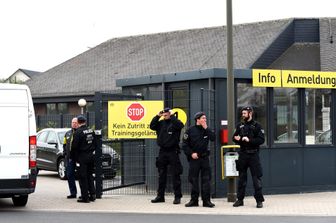 Poliziotti di fronte all'ingresso principale del campo di allenamento del Borussia Dortmund prima della sessione di allenamento di oggi, dopo l'attacco esplosivo al bus della squadra prima della gara di Champions League contro il Monaco (Afp)&nbsp;