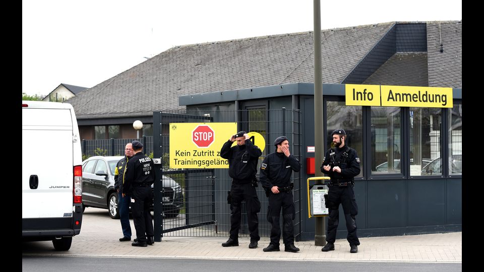 Poliziotti di fronte all'ingresso principale del campo di allenamento del Borussia Dortmund prima della sessione di allenamento di oggi, dopo l'attacco esplosivo al bus della squadra prima della gara di Champions League contro il Monaco (Afp)&nbsp;