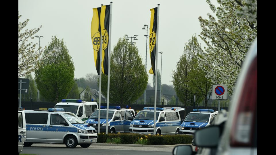 Auto della polizia di fronte l'ingresso principale del campo di allenamento del Borussia Dortmund il giorno dopo l'attacco al bus della squadra (Afp)