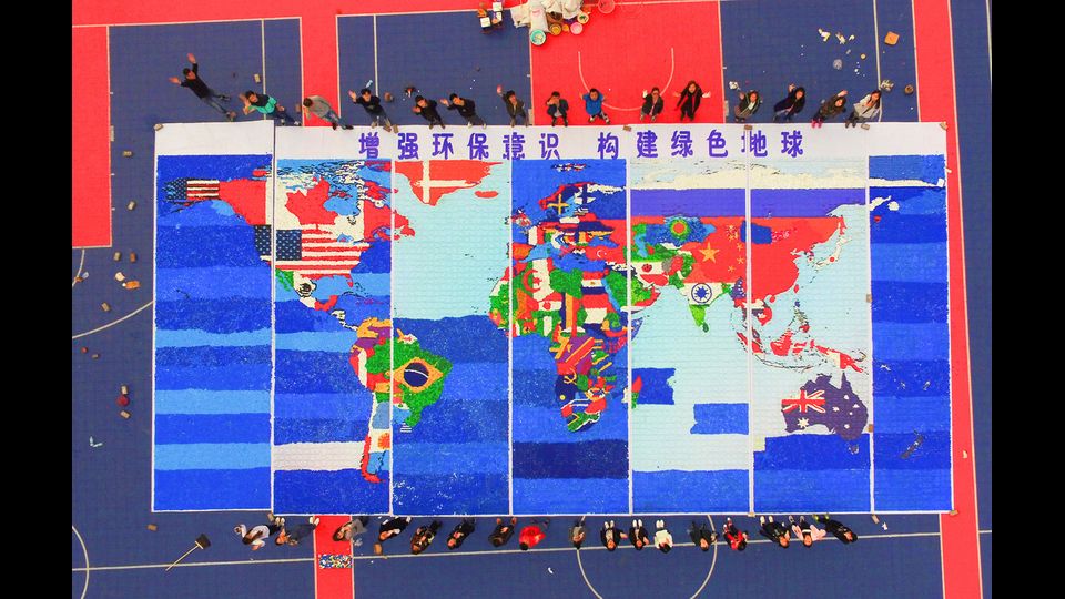 Un bandiera del mondo interamente realizzata con 300mila tappi di plastica: &egrave; l'idea realizzata da alcuni studenti universitari cinesi per celebrare la giornata della Terra. (Afp)&nbsp;