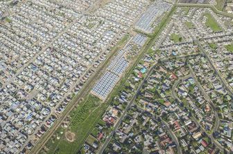 Johnny Miller &egrave; un antropologo che ha deciso di darsi alla fotografia per documentare le diseguaglianze. Il suo lavoro si &egrave; svolto principalmente in Sudafrica, ma anche Kenya e Messico sono state mete delle sue ricerche. Sul suo sito &nbsp;si trovano testimonianze di come in alcune metropoli del mondo ricchezza e povert&agrave; convivano fianco a fianco.Nomzamo/Lwandle &egrave; un 'hotspot' dei problemi economici, sociali e razziali del Sudafrica.   In origine pensato come luogo di residenza per lavoratori di colore durante l&rsquo;apartheid, conta oggi 60.000 abitanti. Intorno vi sono state costruite le comunit&agrave; di Strand e di Somerset West. La prima in particolare &egrave; una cittadina piuttosto benestante. Nella foto, Strand sulla destra e Somerset West sulla sinistra: in mezzo, gli accampamenti di Nomzano/Lwandle, circondati da ringhiere. Questo nucleo abitativo &egrave; stato sgomberato dalle autorit&agrave;, ma successivamente le baracche sono state ricostruite.