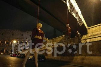 Tre manichini impiccati con addosso le maglie di tre giocatori della Roma: Daniele De Rossi, Mohamed Salah e Radja Nainggolan. Questa &egrave; la scena che si &egrave; presentata nella notte ai passanti a via degli Annibaldi, a due passi dal Colosseo. I manichini erano stati fatti penzolare dal ponte pedonale sovrastante, sul quale &egrave; stato affisso uno striscione intimidatorio che recita: &quot;Un consiglio senza offesa, dormite con la luce accesa&quot; (foto di Retesport).