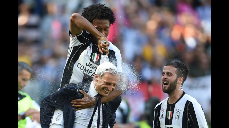 21 maggio 2017&nbsp;Juan Cuadrado festeggia con l'allenatore Massimiliano Allegri la vittoria dello scudetto al termine della partita con il Crotone. (Afp)