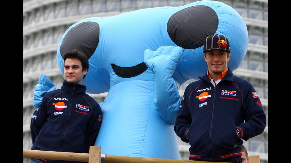 &nbsp;Nicky Hayden con il compagno di squadra Dani Pedrosa posano davanti alla mascotte di Zaragoza Expo prima della loro presentazione ufficiale a Saragozza il 14 febbraio 2008 (Afp)