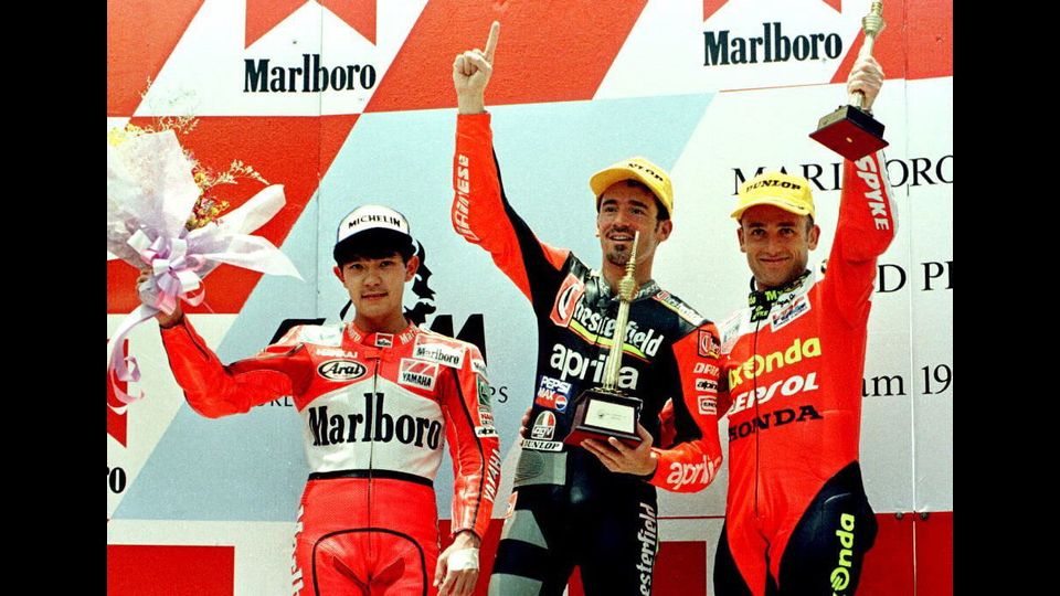Il campione del mondo Max Biaggi sul podio con Tetsuya Harada e Luis D'Atin per la cerimonia di premiazione al &nbsp;World 250cc Motrocycle Malaysian Grand Prix a Shah Alam, 31 marzo 1996&nbsp;