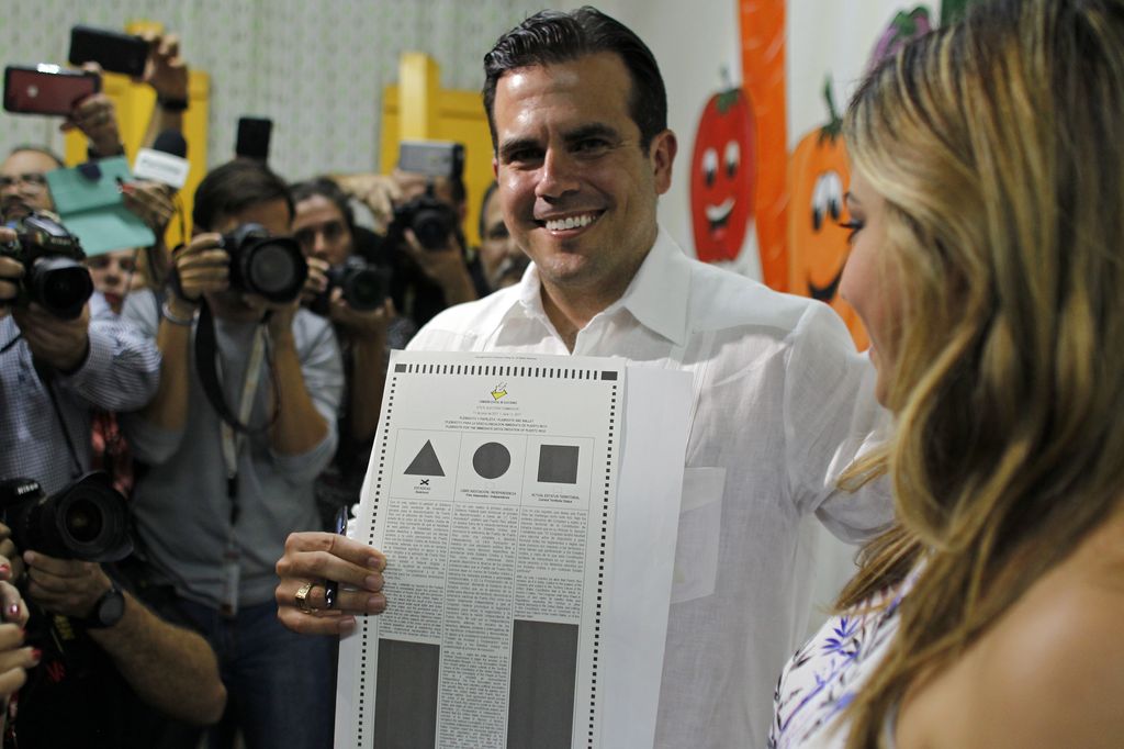 Il governatore Ricardo Rossello durante il voto mostra le tre opzioni tra cui scegliere (Afp)