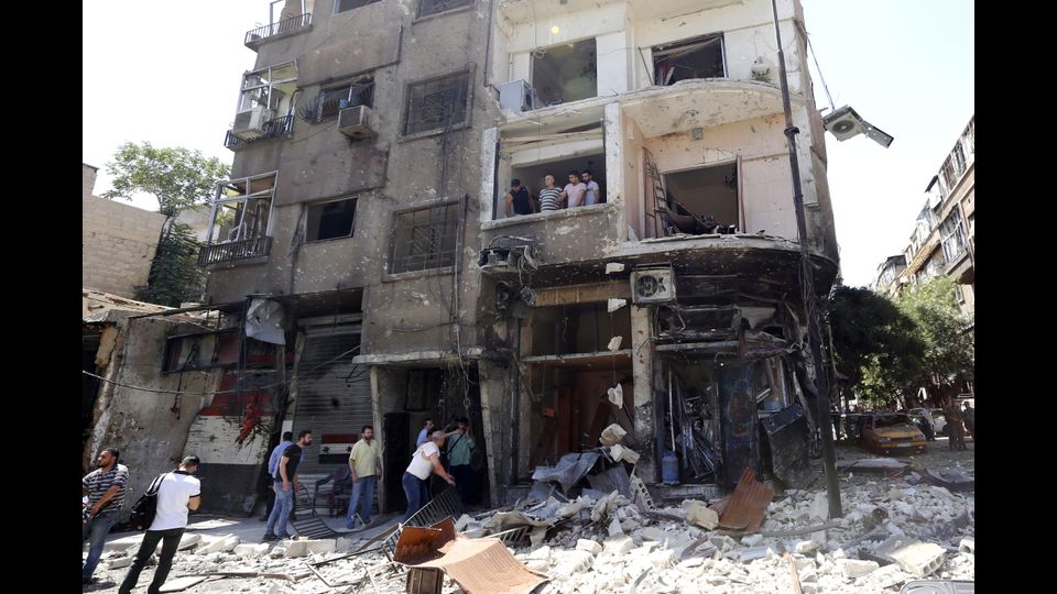 &nbsp;I danni alle strade e alle abitazioni dopo l&igrave;attentato suicida avvenuto a piazza Tahrir, nella parte est di Damasco all'alba (Afp)