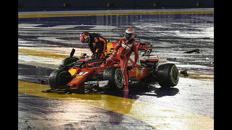 Il pilota della Ferrari, Kimi Raikkonen e il pilota della Red Bull, Max Verstappen, mentre escono dalle loro monoposto dopo un incidente durante il Gran Premio di Singapore (Afp)&nbsp;