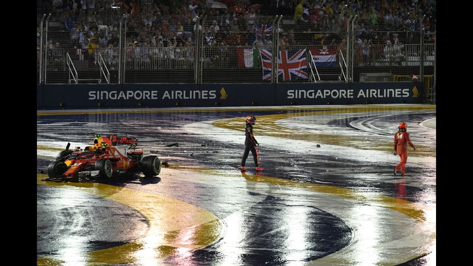 Il pilota della Ferrari, Kimi Raikkonen e il pilota della Red Bull, Max Verstappen, mentre si allontanano dalle loro monoposto dopo un incidente durante il Gran Premio di Singapore (Afp)&nbsp;