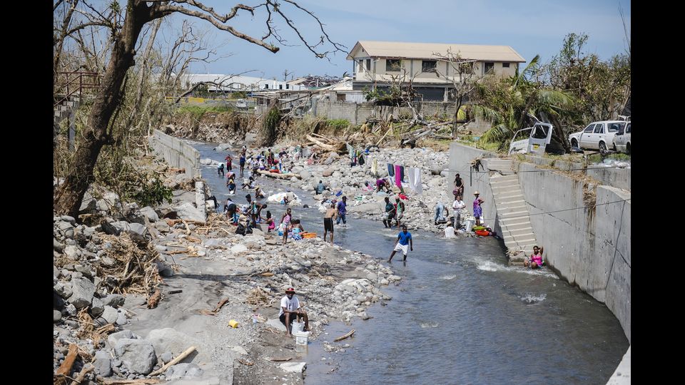 Gli abitanti di Canefield, rimasti senza dimora dopo il passaggio dell'uragano Maria, si lavano lungo le rive di un fiume (Afp)&nbsp;