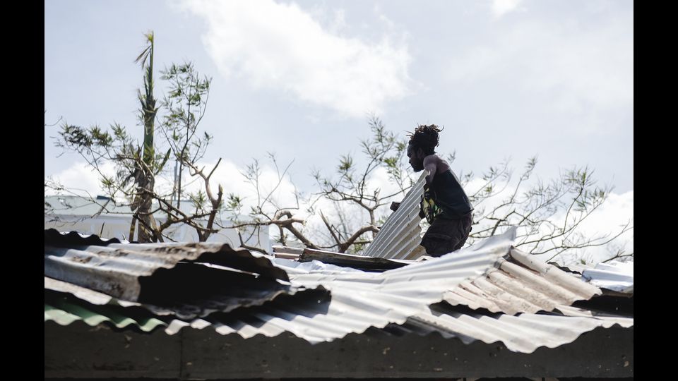 Un uomo cerca di riparare il tetto della sua casa a Canefield, distrutta dall'uragano Maria (Afp) &nbsp;