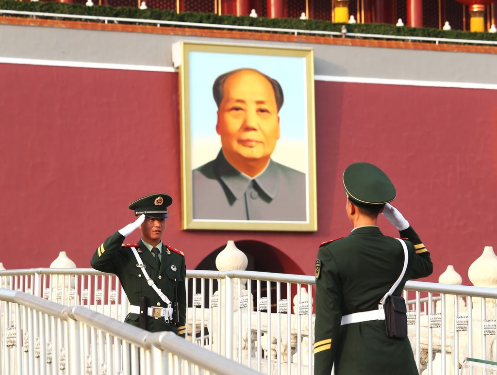 &nbsp;Due poliziotti cinesi di fronte a un ritratto di Mao