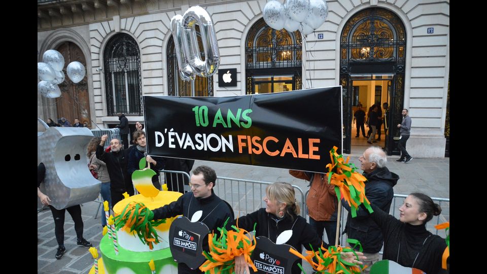 Davanti agli Apple Store non sono mancati picchetti di manifestanti che chiedono alla compagnia di rinunciare alle disinvolte pratiche di &quot;ottimizzazione fiscale&quot; che, nell'agosto 2016, hanno costretto Bruxelles a intimare a Cupertino di restituire 13 miliardi di tasse all'Irlanda, dove l'azienda pagava un'aliquota effettiva sugli utili dello 0,005%. Cook boll&ograve; la richiesta come &quot;political crap&quot;, letteralmente: &quot;stronzata politica&quot;.