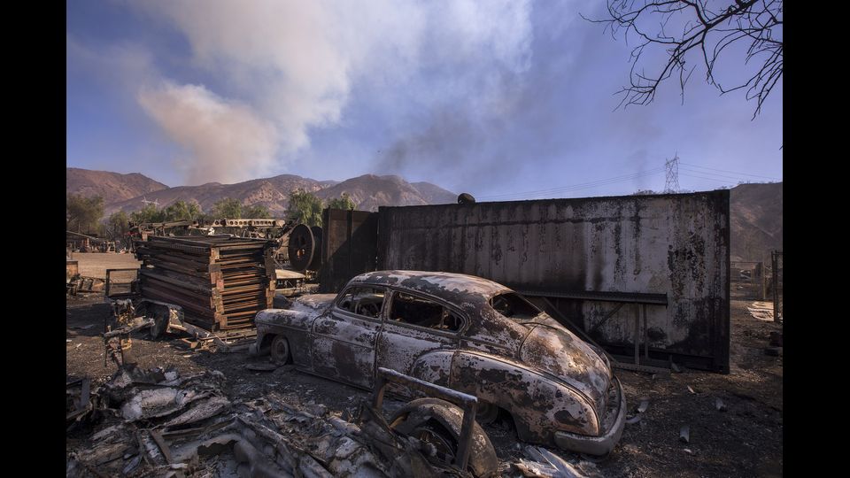 Un'auto distrutta nel quartiere di Sylmar a Los Angeles in California. Il fuoco ialimentato da forti venti di Santa Ana ha bruciato pi&ugrave; di 15.000 acri e causato l'evacuazione di 150.000 residenti.