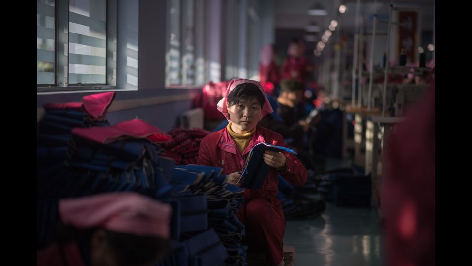 Una donna al lavoro in un laboratorio presso la &quot;Pyongyang Bag Factory&quot; a Pyongyang