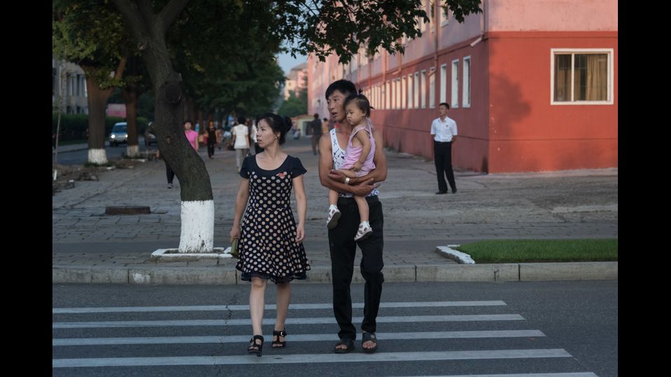 Una famiglia attraversa una strada a Pyongyang