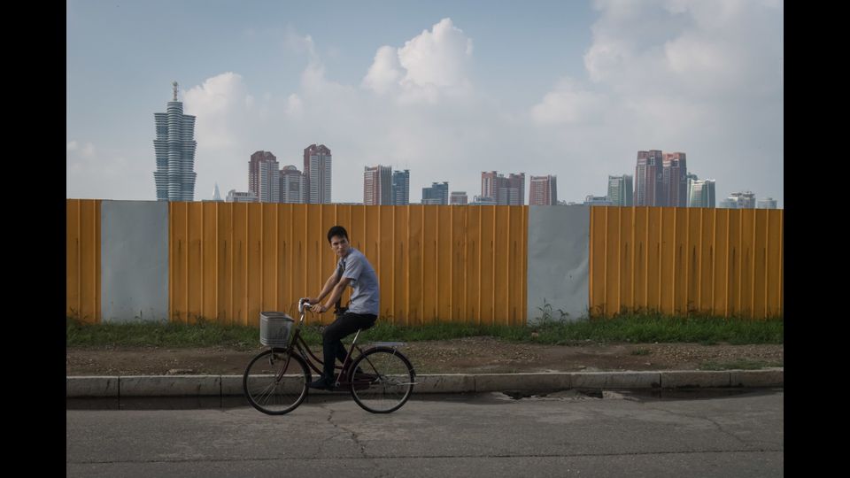 Un uomo in bicicletta lungo una strada a Pyongyang