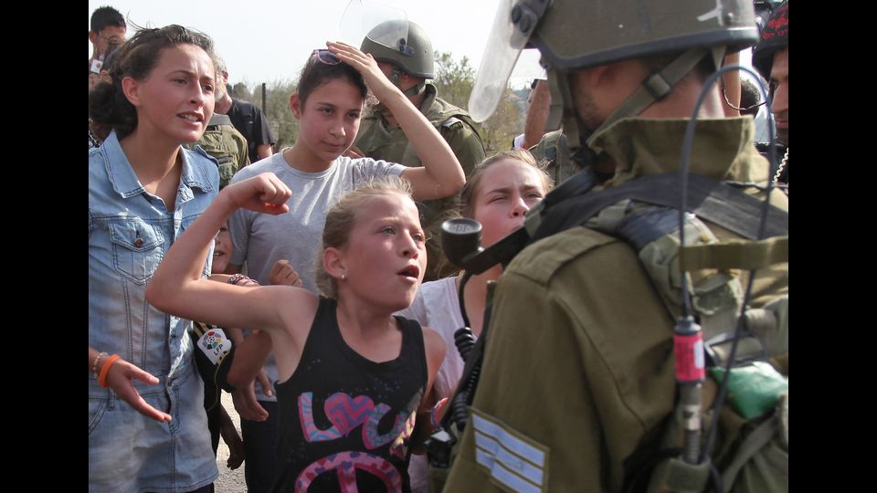 Ahed Tamimi fa gesti minacciosi di fronte a un soldato israeliano il 2 novembre 2012, durante una protesta contro la confisca di terra palestinese da parte di Israele nel villaggio di Nabi Saleh vicino a Ramallah, in Cisgiordania (Afp)&nbsp;