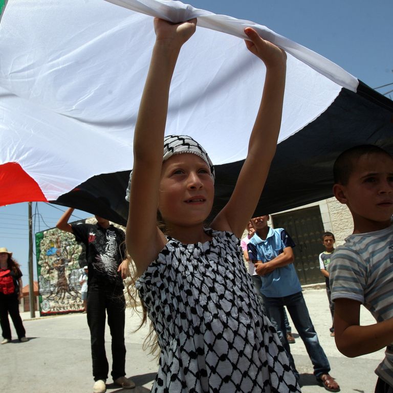 Ahed Tamimi alza la sua bandiera nazionale mentre prende parte a una manifestazione di protesta il 10 giugno 2011, contro l'espropriazione della terra palestinese, nel villaggio di Nabi Saleh, nella Cisgiordania occupata da Israele (Afp)&nbsp;