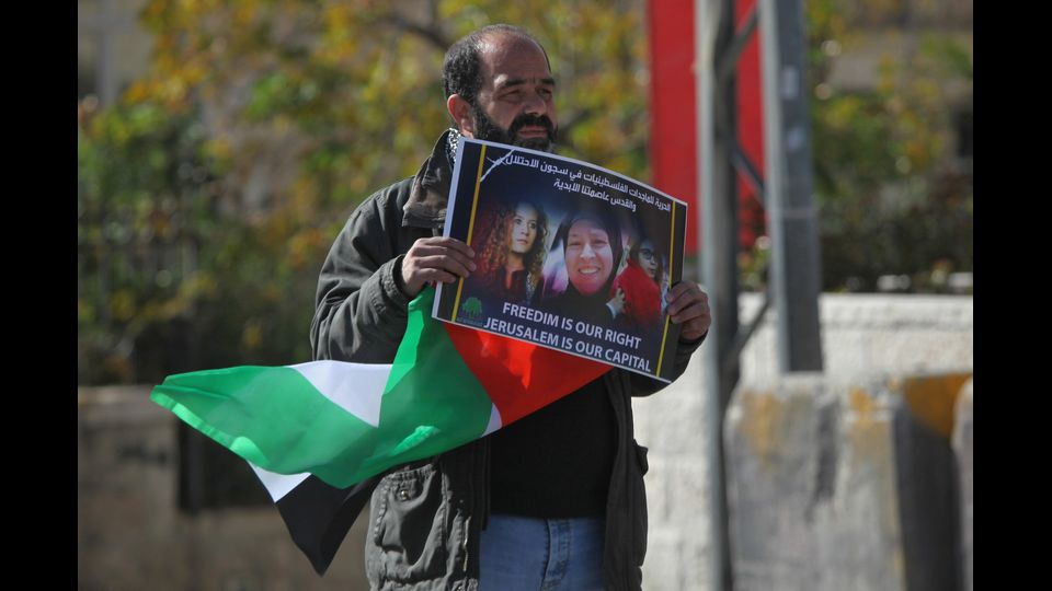 Un uomo palestinese tiene un poster della sedicenne palestinese Ahed al-Tamimi, che &egrave; stata presa in custodia dai soldati israeliani urante una protesta contro l'annuncio del presidente degli Stati Uniti Donald Trump a riconoscere Gerusalemme come capitale di Israele, il 27 dicembre 2017 a Betlemme, in Cisgiordania (Afp)&nbsp;