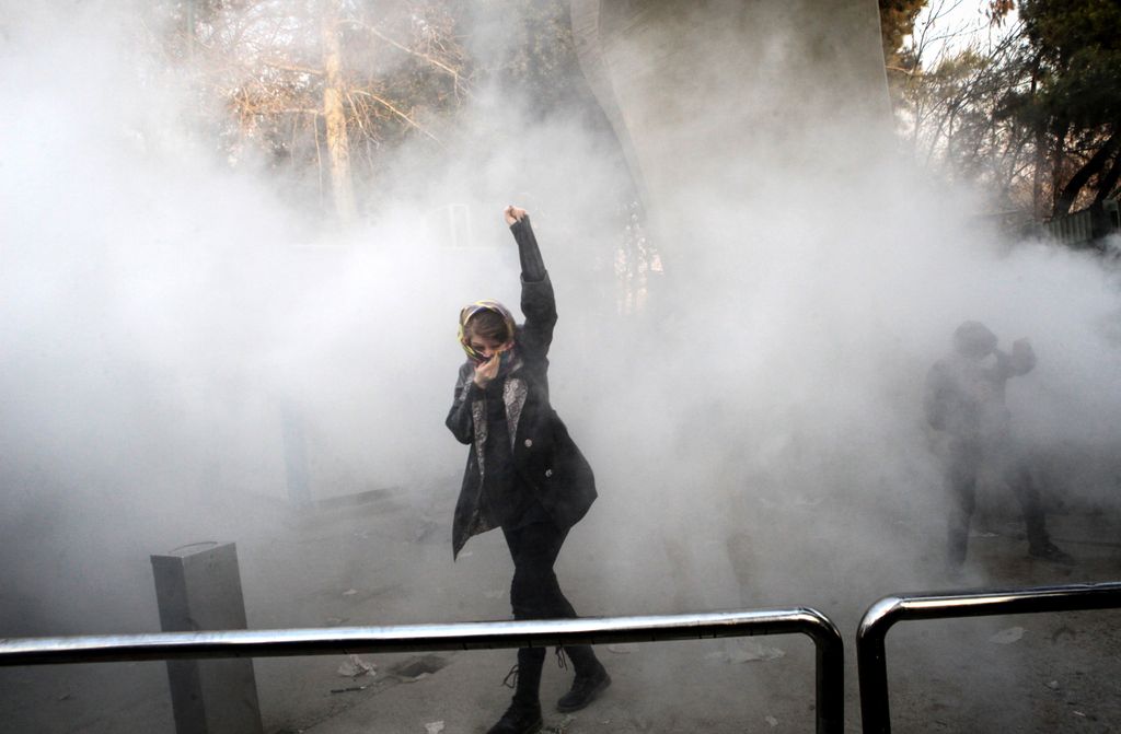 &nbsp;Una manifestante in mezzo al fumo dei lacrimogeni a Teheran