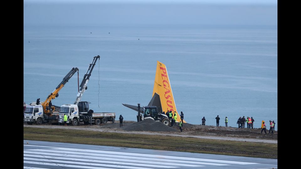 I mezzi di soccorso cercano di bloccare l'areo della Pegasus per non farlo scivolare in mare, slittato fuori pista dopo l'atterraggio all'aeroporto di Trebisonda