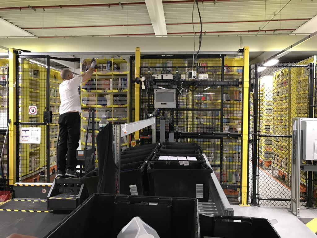 &nbsp;Amazon, Passo Corese. Un dipendente raccoglie dalle pile robotizzate un oggetto per essere spedito