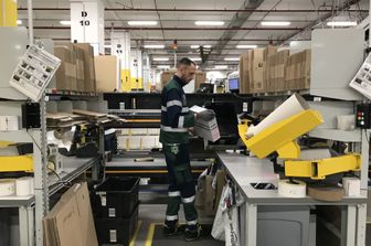 Un dipendente di Amazon nel centro di Passo Corese, Rieti. La selezione delle scatole per fare i pacchetti