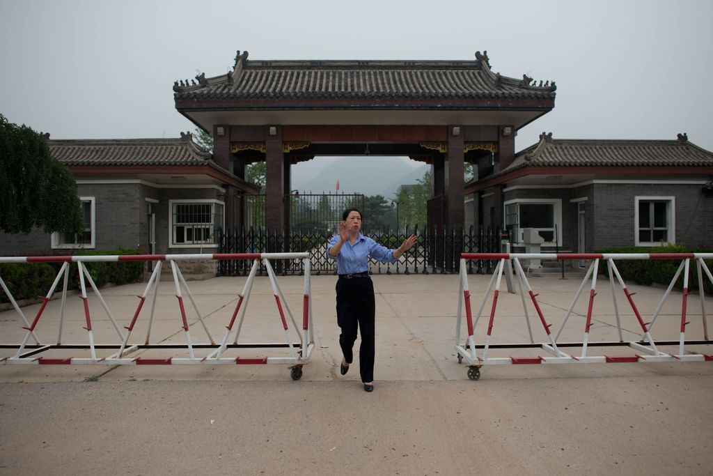 &nbsp;Una poliziotta sbarra la strada ai fotografi di fronte all'ingresso della prigione di Qincheng