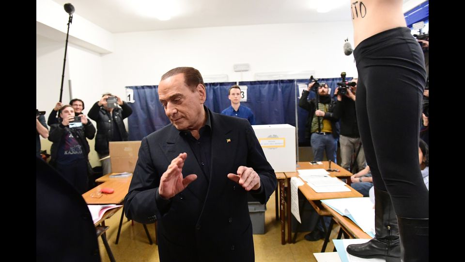 &nbsp;La Femen si e' intrufolata tra i giornalisti, fotografi e cameramen entrati nel seggio e si e' in parte mostrando il seno e la schiena su cui aveva tracciato la scritta &quot;Berlusconi sei scaduto&quot;. &quot;Il tempo e' scaduto, Berlusconi! Sei scaduto!&quot;, ha urlato.